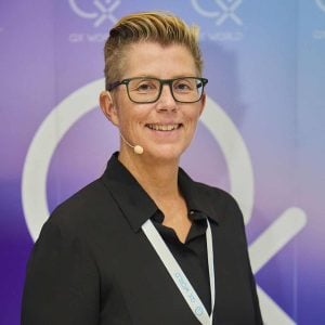 Confident woman at conference with microphone and badge