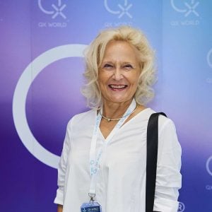 Smiling woman in white at business event background